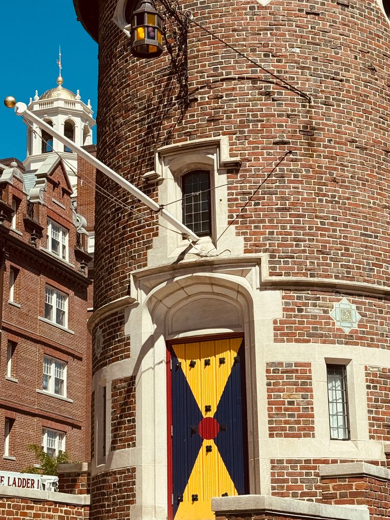 A brick tower with a colorful door on Harvard's campus, featuring classic architecture in Boston.